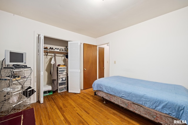 bedroom featuring hardwood / wood-style floors and a closet