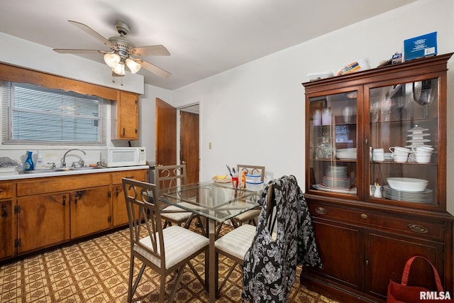 dining area featuring ceiling fan and sink