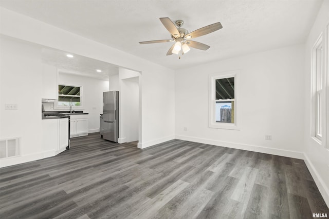 unfurnished living room with a textured ceiling, dark hardwood / wood-style floors, ceiling fan, and sink