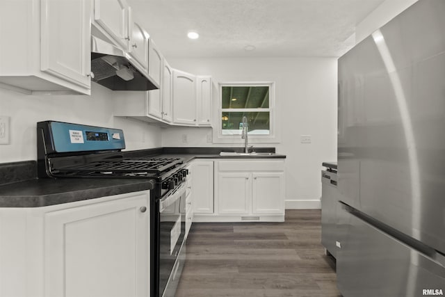 kitchen featuring a textured ceiling, stainless steel appliances, dark wood-type flooring, sink, and white cabinets