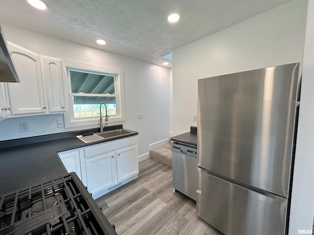 kitchen featuring white cabinetry, sink, stainless steel appliances, and light wood-type flooring