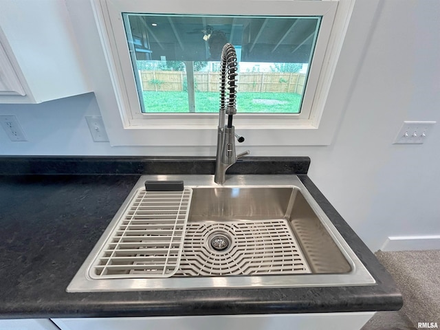 interior details with white cabinetry and sink