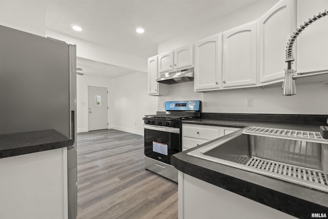 kitchen with gas stove, light hardwood / wood-style floors, and white cabinetry