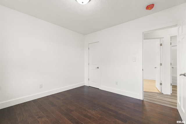 spare room featuring wood-type flooring and a textured ceiling