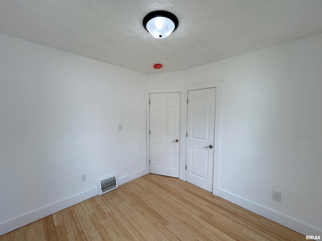 unfurnished bedroom featuring light hardwood / wood-style floors and a textured ceiling