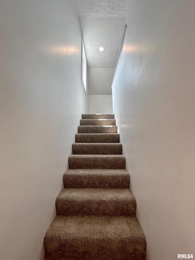 stairs with a textured ceiling