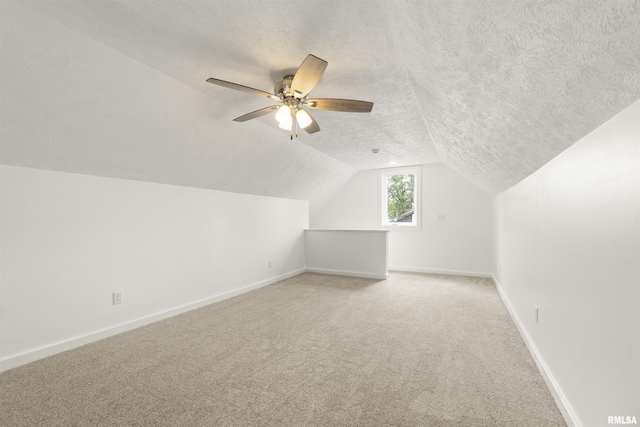 additional living space with carpet flooring, lofted ceiling, ceiling fan, and a textured ceiling