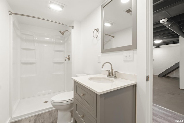 bathroom featuring vanity, toilet, wood-type flooring, and walk in shower