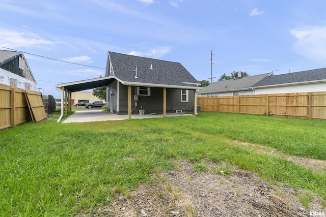 rear view of house featuring a yard and a carport