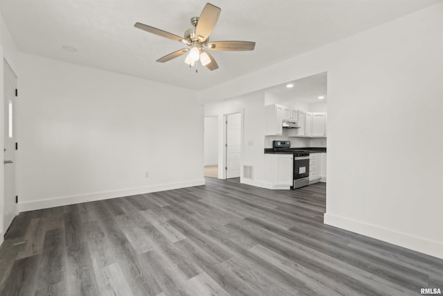 unfurnished living room featuring ceiling fan and dark wood-type flooring