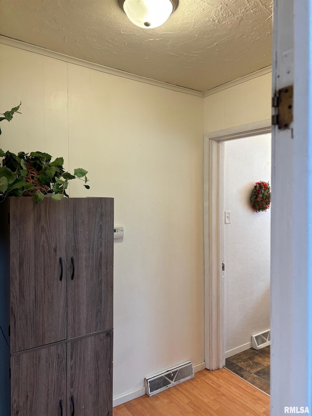 hallway featuring hardwood / wood-style floors and a textured ceiling