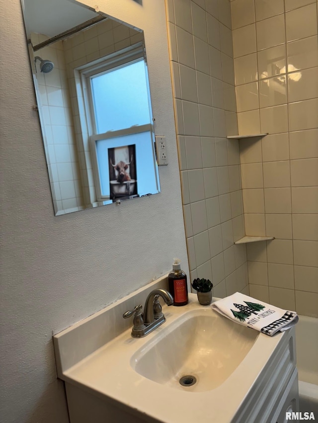 bathroom featuring vanity and tiled shower / bath