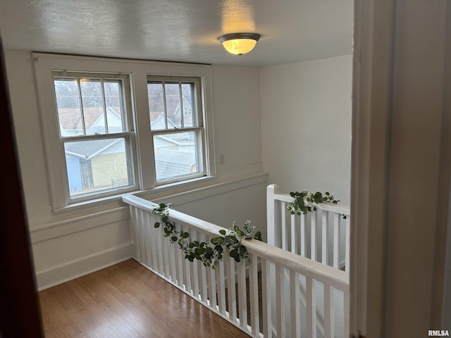 hall featuring wood-type flooring and a textured ceiling