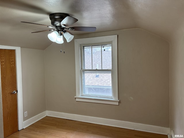 additional living space featuring ceiling fan, lofted ceiling, a textured ceiling, and light hardwood / wood-style flooring