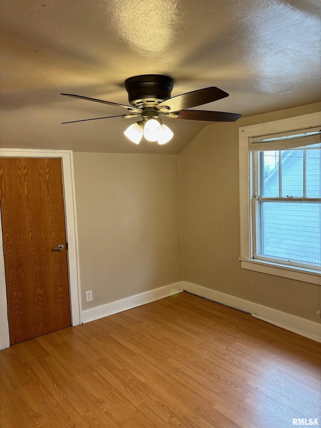 unfurnished room featuring ceiling fan, light hardwood / wood-style flooring, and a textured ceiling