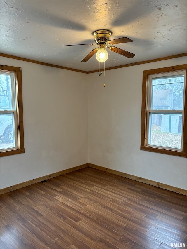 spare room with ceiling fan, crown molding, and dark wood-type flooring