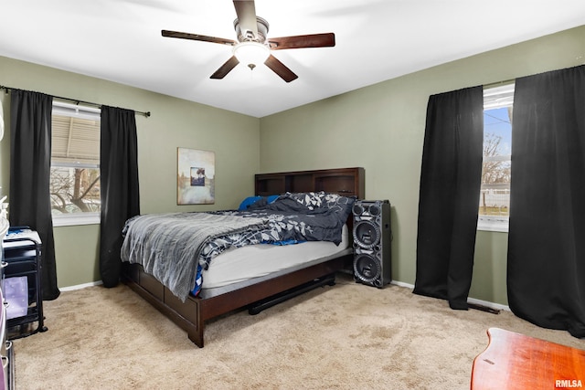 carpeted bedroom with ceiling fan and multiple windows