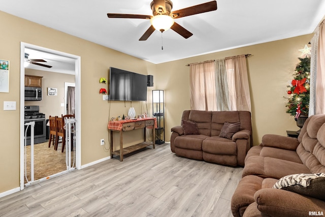 living room with light hardwood / wood-style flooring and ceiling fan