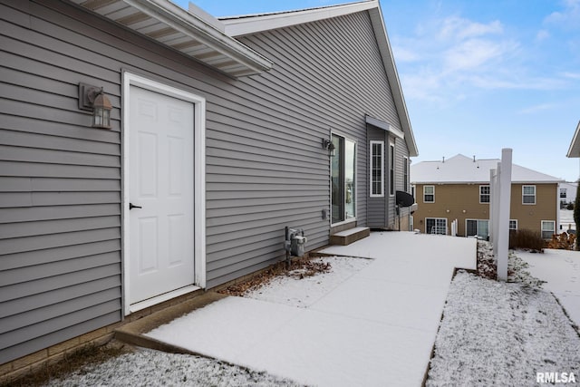 view of snow covered back of property