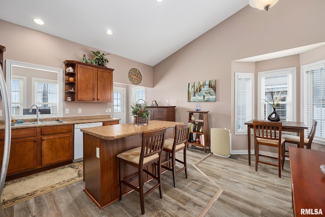 kitchen with dishwasher, a center island, light wood-type flooring, and a wealth of natural light