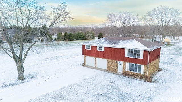 snow covered property with a garage