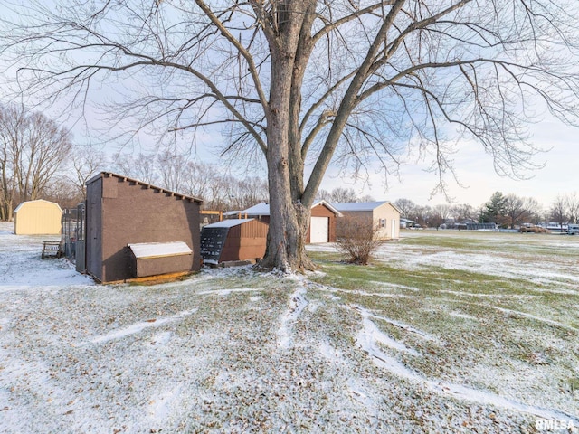 yard covered in snow with a storage shed