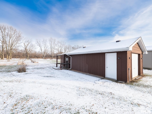 snow covered structure with a garage