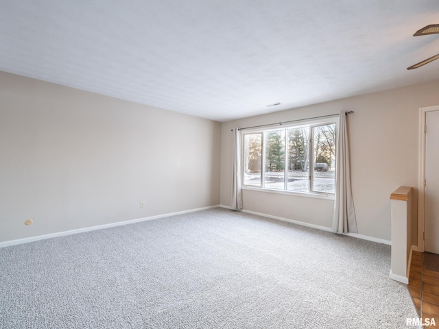 carpeted spare room featuring ceiling fan