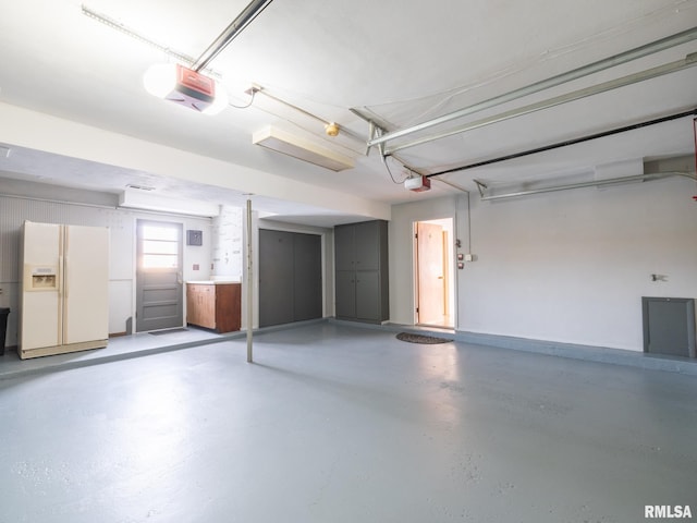 garage featuring white fridge with ice dispenser and a garage door opener