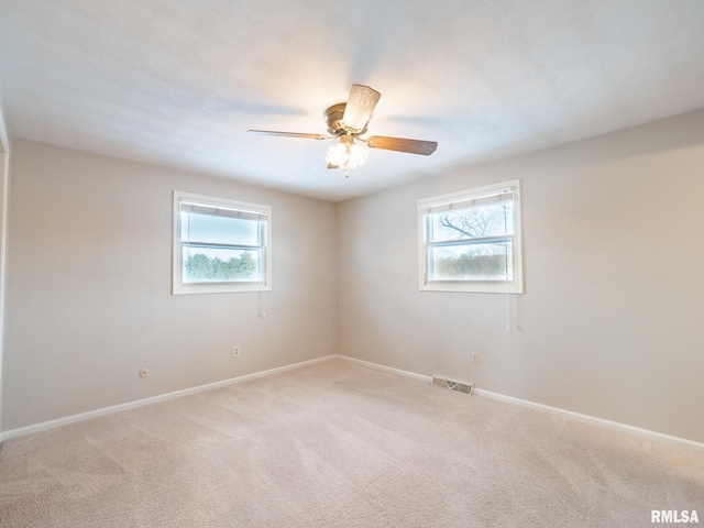 carpeted empty room with plenty of natural light and ceiling fan