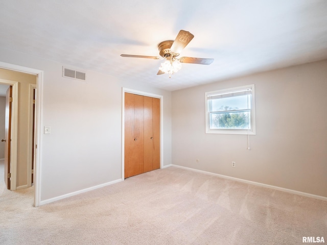 unfurnished bedroom with ceiling fan, a closet, and light colored carpet