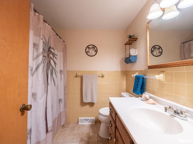 bathroom with tile patterned floors, vanity, tile walls, toilet, and curtained shower