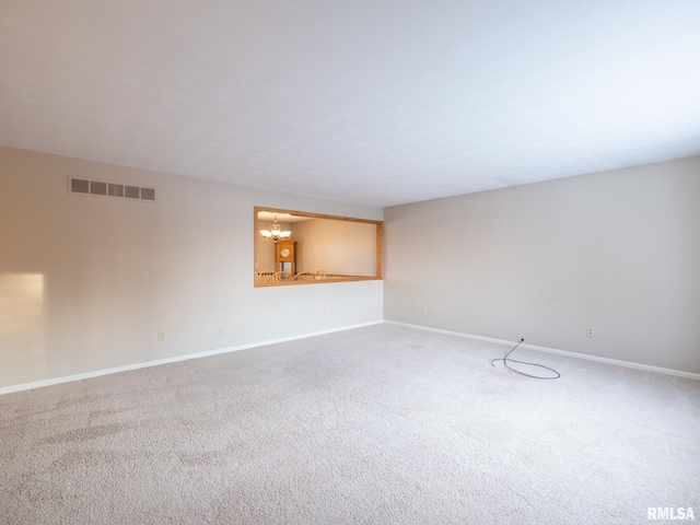 empty room with carpet and a chandelier