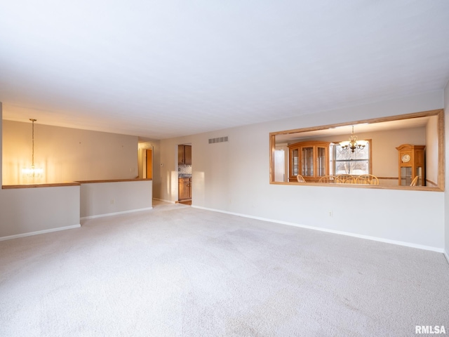 unfurnished room featuring carpet and a chandelier