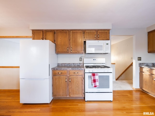 kitchen featuring light hardwood / wood-style floors and white appliances