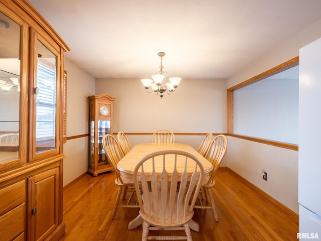 dining area featuring light hardwood / wood-style floors and an inviting chandelier