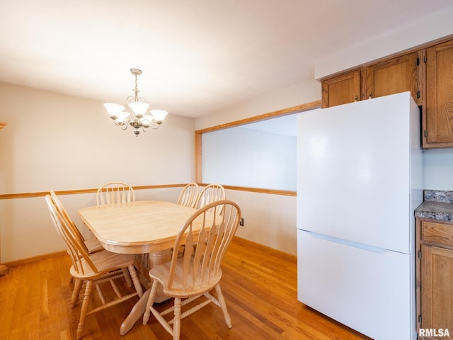 dining area with a chandelier and light hardwood / wood-style floors