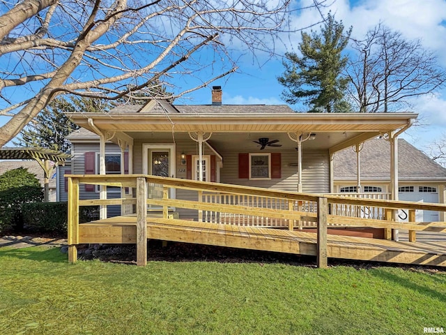 back of property with ceiling fan and a yard