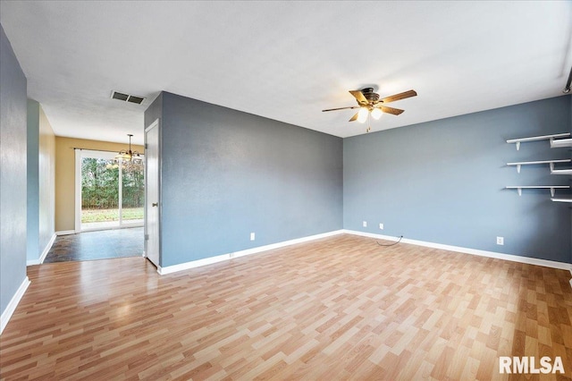 unfurnished room with ceiling fan with notable chandelier and light wood-type flooring