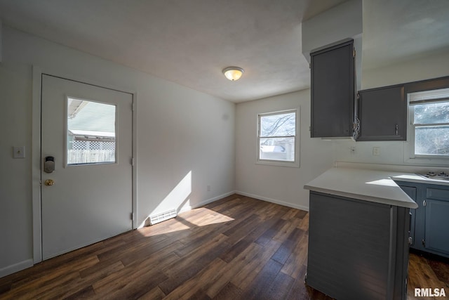 kitchen featuring gray cabinetry, dark wood-type flooring, visible vents, baseboards, and light countertops