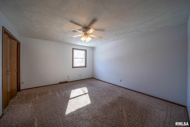 empty room featuring carpet flooring, ceiling fan, a textured ceiling, and baseboards