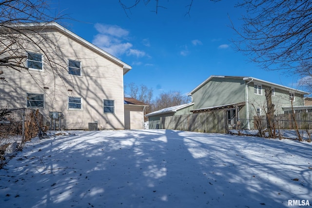 view of snow covered exterior with fence