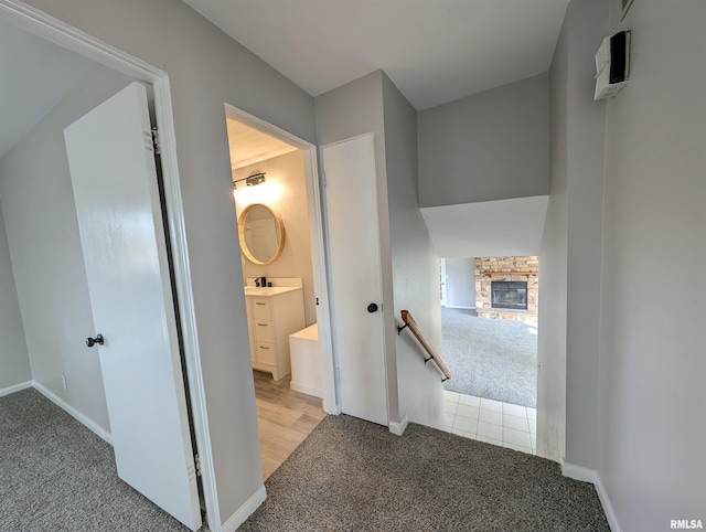 hallway featuring light colored carpet and sink