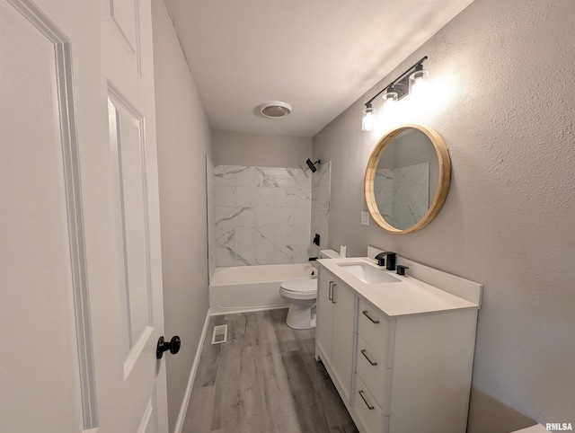 full bathroom featuring toilet, vanity, tiled shower / bath, and hardwood / wood-style floors