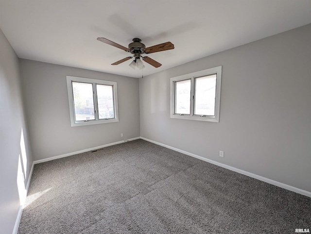 carpeted spare room featuring ceiling fan