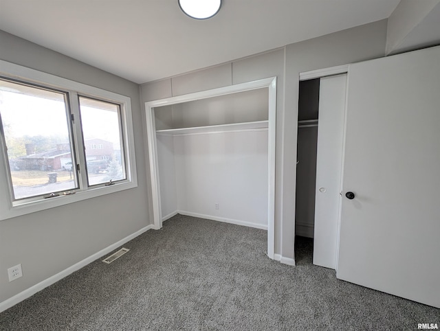 unfurnished bedroom featuring multiple closets and carpet flooring