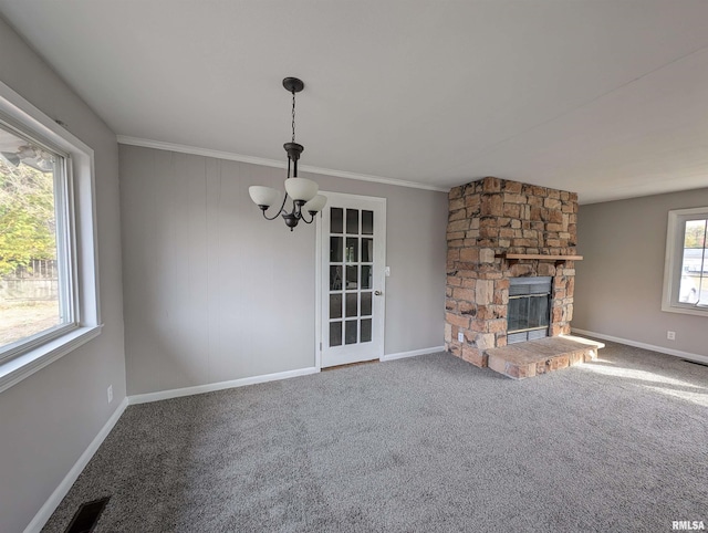 unfurnished living room featuring a wealth of natural light, a chandelier, and a fireplace