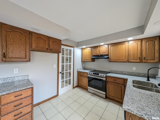 kitchen with light stone counters, electric stove, light tile patterned floors, and sink