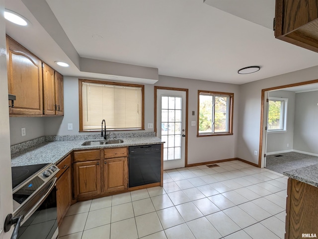 kitchen with dishwasher, sink, light tile patterned flooring, light stone countertops, and stainless steel range with electric cooktop