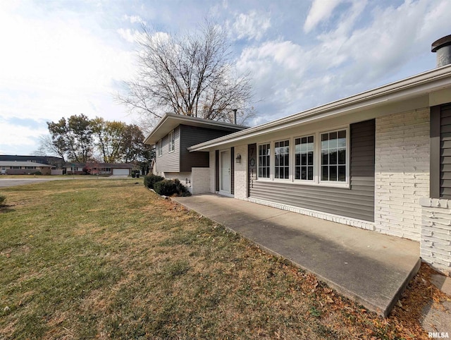 view of side of home with a yard